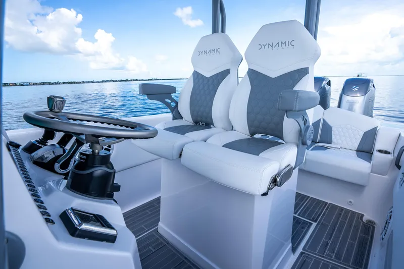 Slide: The Image of 2023 Dynamic D-305V boat interior with modern steering and seating on calm water. - 9