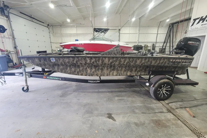 Slide: The Image of 2023 Havac FRRSC boat with camouflage design on trailer in garage. - 5