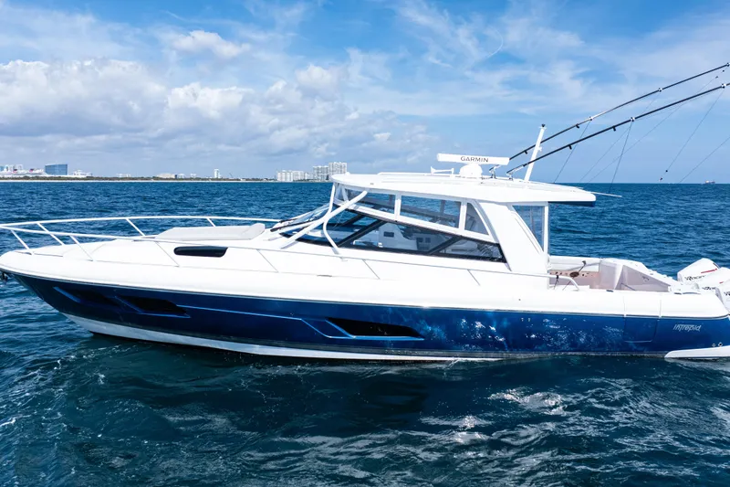 The Image of 2018 Intrepid 438 Evolution yacht cruising on open sea under clear blue sky. - 0