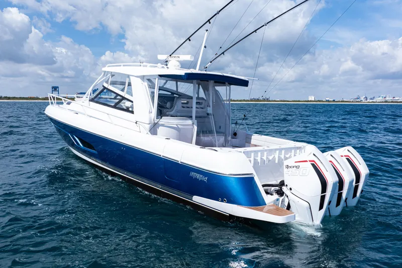 Slide: The Image of 2018 Intrepid 438 Evolution boat on open water, featuring triple outboard engines. - 1