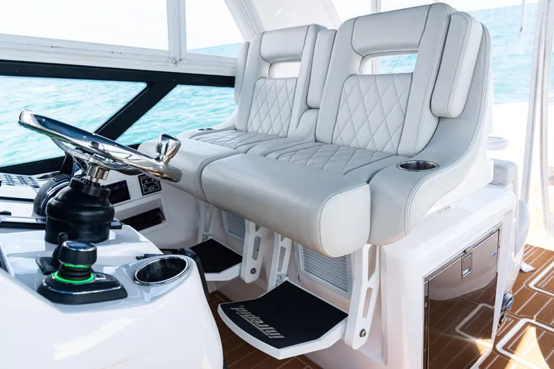 Slide: The Image of Luxurious helm seating on 2018 Intrepid 438 Evolution yacht with modern steering controls. - 13