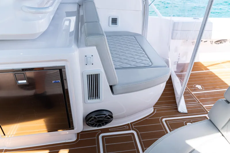 Slide: The Image of Interior of 2018 Intrepid 438 Evolution yacht with cushioned seating and wood-patterned flooring. - 18