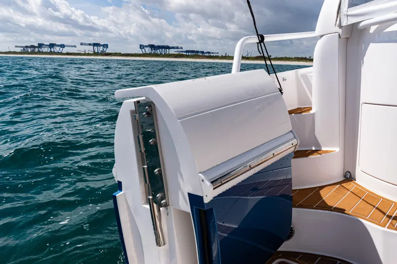 Slide: The Image of 2018 Intrepid 438 Evolution yacht on water, featuring sleek design and wooden deck. - 43