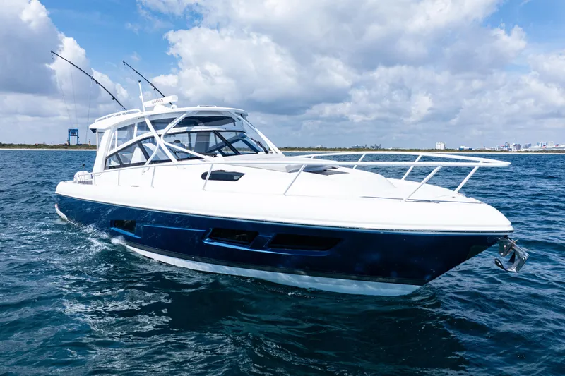 Slide: The Image of 2018 Intrepid 438 Evolution yacht cruising on open water under a cloudy sky. - 5