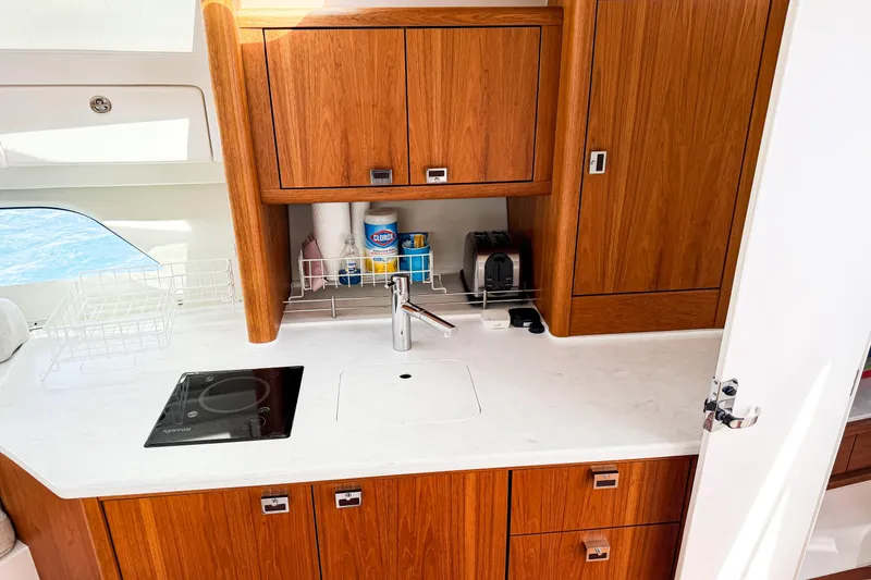 Slide: The Image of Modern kitchen area in 2018 Intrepid 438 Evolution yacht with wooden cabinets and sleek appliances. - 53