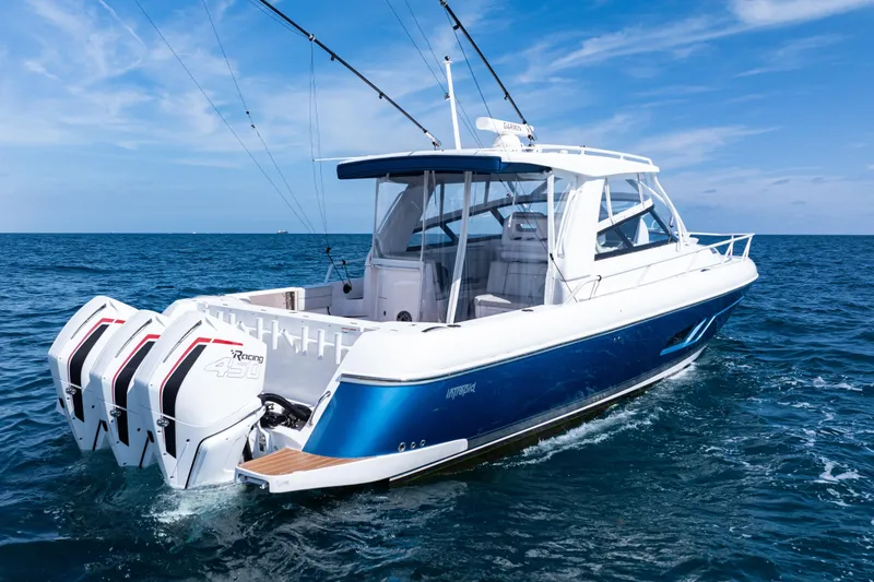Slide: The Image of 2018 Intrepid 438 Evolution boat cruising on open sea with clear blue skies. - 6
