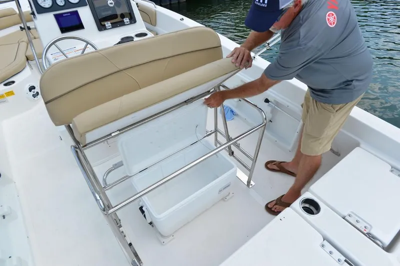 Slide: The Image of Manufacturer Provided Image: 2021 NauticStar 211 Hybrid boat interior with man accessing storage compartment. - 13