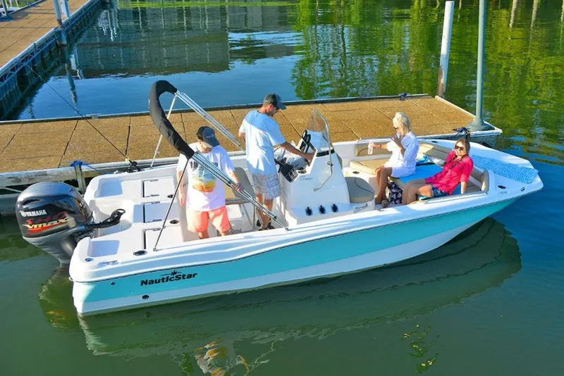 Slide: The Image of Manufacturer Provided Image: 2021 NauticStar 211 Hybrid boat with passengers on a calm lake near a dock. - 6
