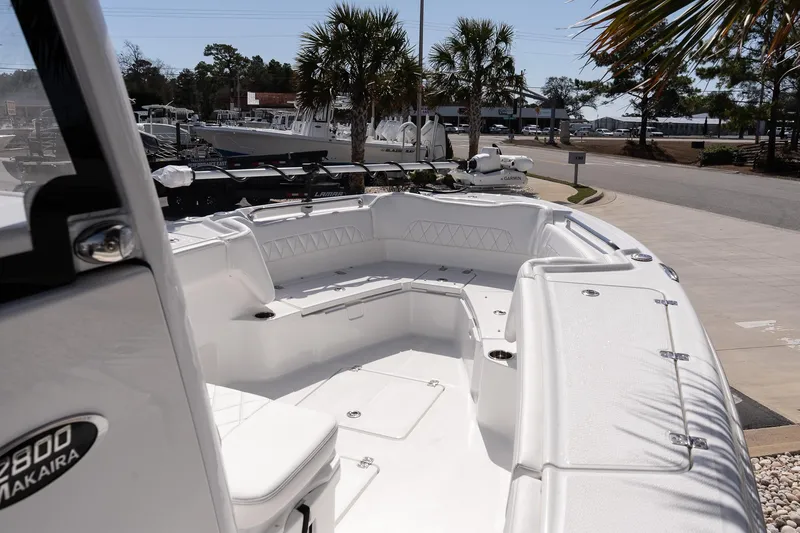 Slide: The Image of 2026 Blazer Bay Makaira 2800 boat interior with seating, docked near palm trees. - 13