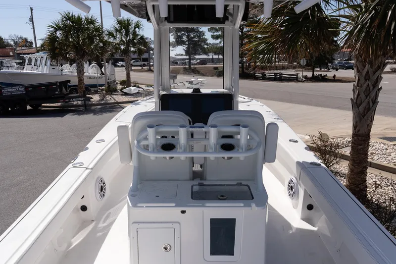 Slide: The Image of 2026 Blazer Bay Makaira 2800 boat interior with dual seats and console, parked outdoors. - 8