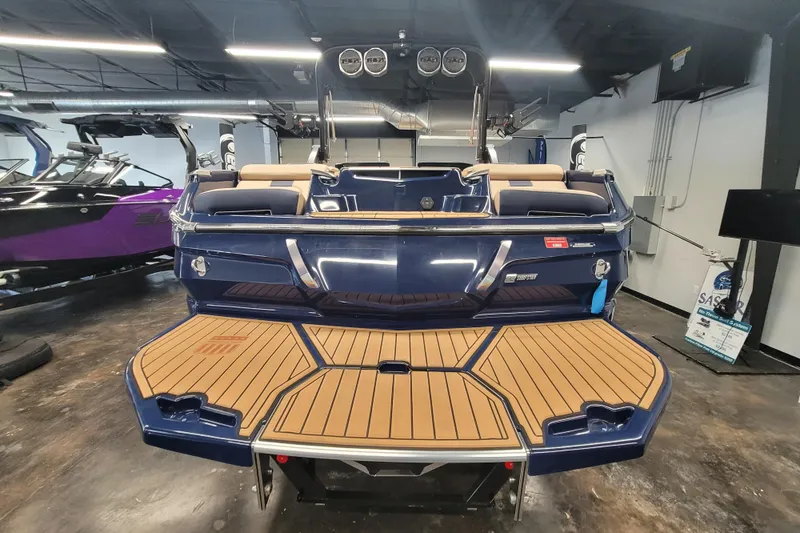 Slide: The Image of 2025 MasterCraft X24 boat with sleek design and spacious deck in showroom. - 4