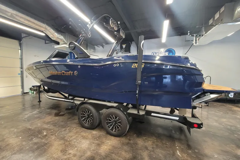 Slide: The Image of 2025 MasterCraft X24 boat in showroom, blue exterior, on trailer. - 5