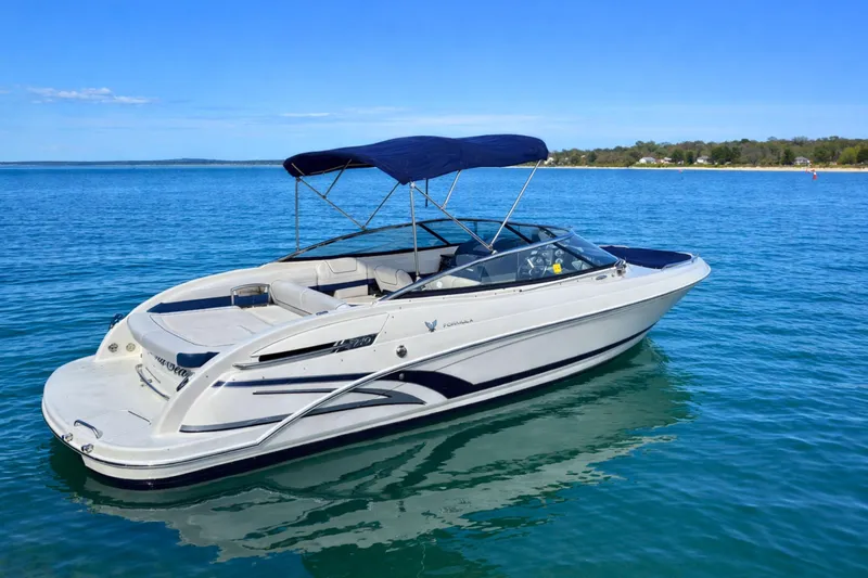 Slide: The Image of 2015 Formula 240 Bowrider boat on open water, featuring spacious seating and sleek design. - 2