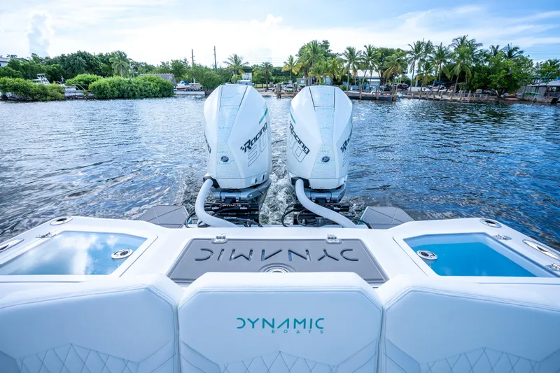 Slide: The Image of 2024 Dynamic D-305V boat with twin engines on a scenic waterway. - 23