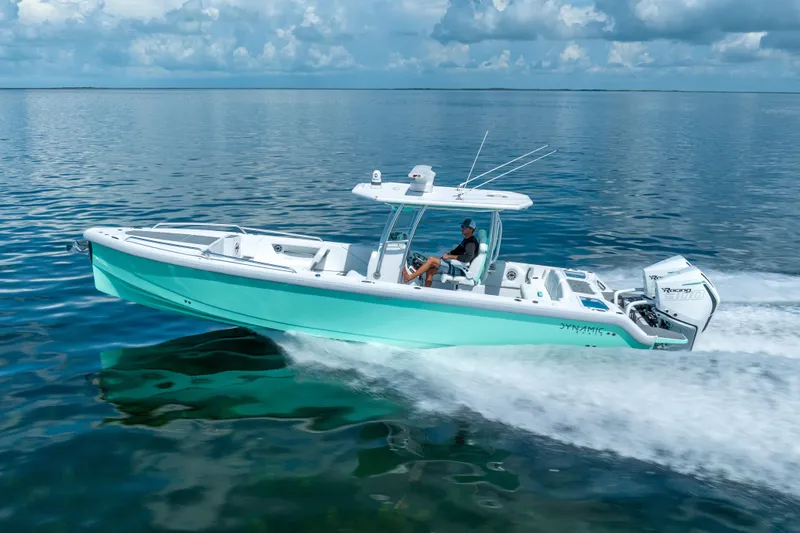 Slide: The Image of 2024 Dynamic D-305V boat cruising on calm ocean waters under a cloudy sky. - 3
