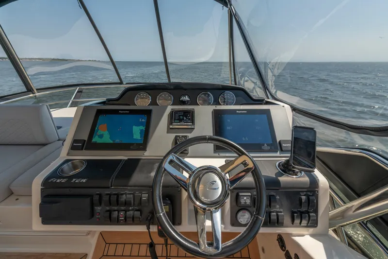 Slide: The Image of 2017 Sea Ray Fly 510 yacht helm with navigation screens and steering wheel. - 74