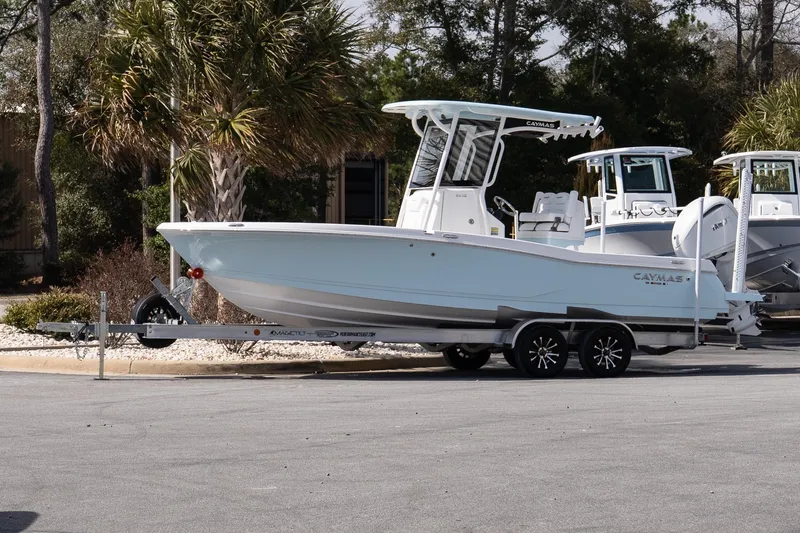 The Image of 2026 Caymas 24 HB boat on trailer, parked outdoors near palm trees. - 1