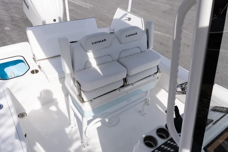 Slide: The Image of 2026 Caymas 24 HB boat interior with white cushioned seating and cup holders. - 10