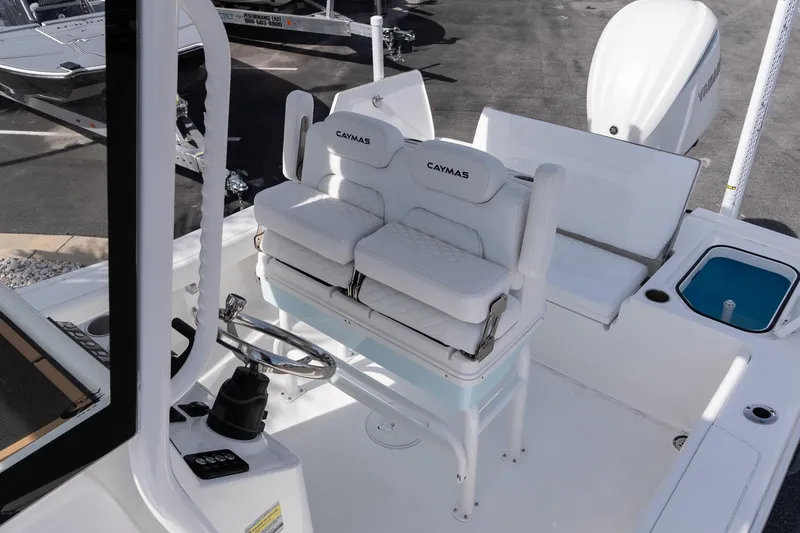 Slide: The Image of 2026 Caymas 24 HB boat interior with cushioned seating and steering wheel. - 11