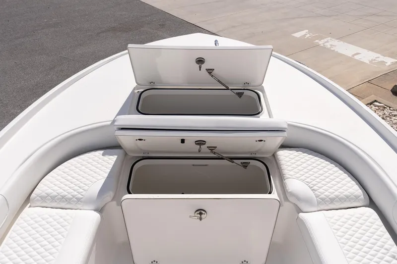 Slide: The Image of 2026 Caymas 24 HB boat with open storage compartments and quilted seating. - 20