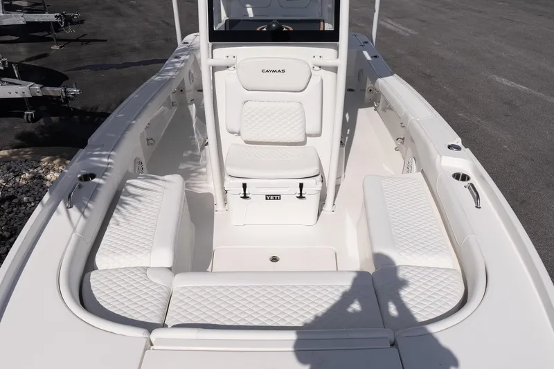 Slide: The Image of 2026 Caymas 24 HB boat interior with white cushioned seating and Yeti cooler. - 22