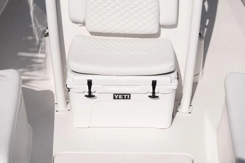 Slide: The Image of White YETI cooler on 2026 Caymas 24 HB boat with cushioned seat. - 23