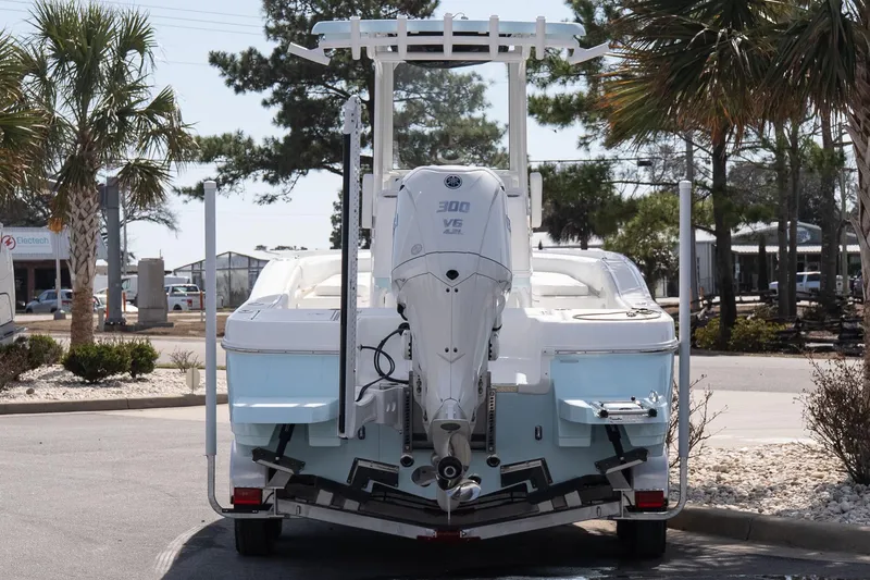 Slide: The Image of 2026 Caymas 24 HB boat with powerful 300 V6 engine, parked outdoors. - 4