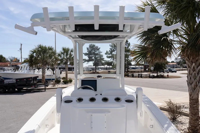 Slide: The Image of 2026 Caymas 24 HB boat with T-top, docked near palm trees. - 6