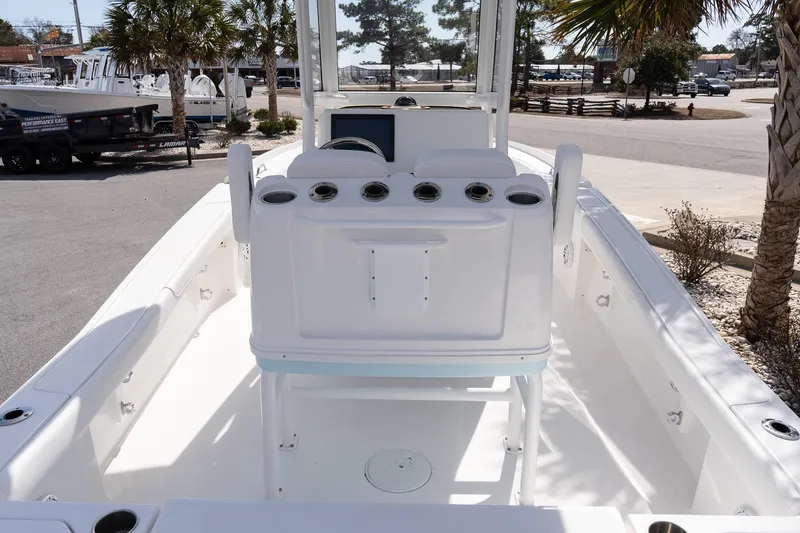 Slide: The Image of 2026 Caymas 24 HB boat interior with console, palm trees in background. - 7