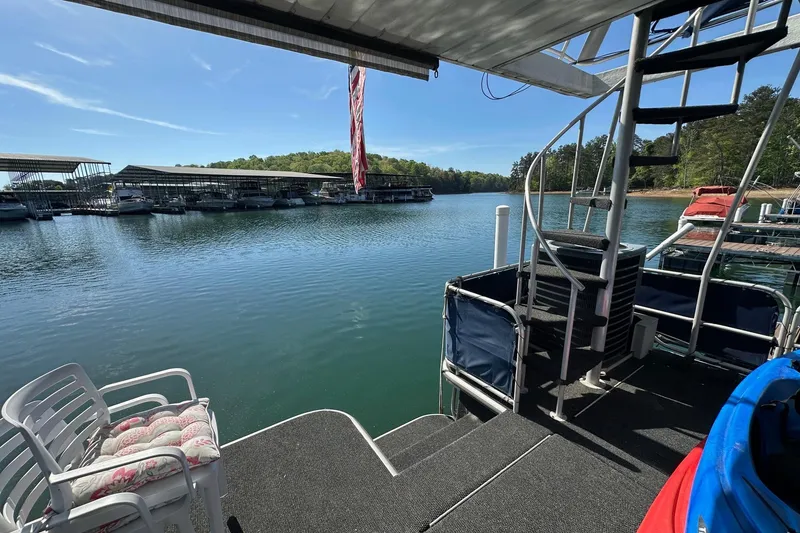 Slide: The Image of Houseboat deck view with spiral staircase, overlooking marina and calm water. Starlite 15x67, 2001. - 15