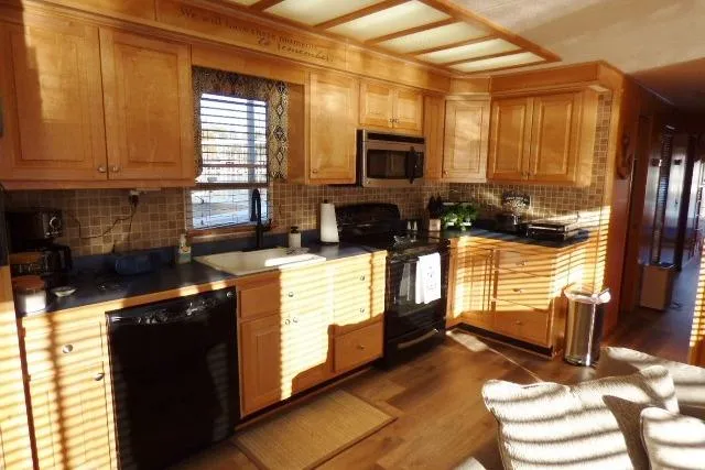 Slide: The Image of Modern kitchen in a 2001 Starlite 15x67, featuring wooden cabinets and stainless steel appliances. - 4