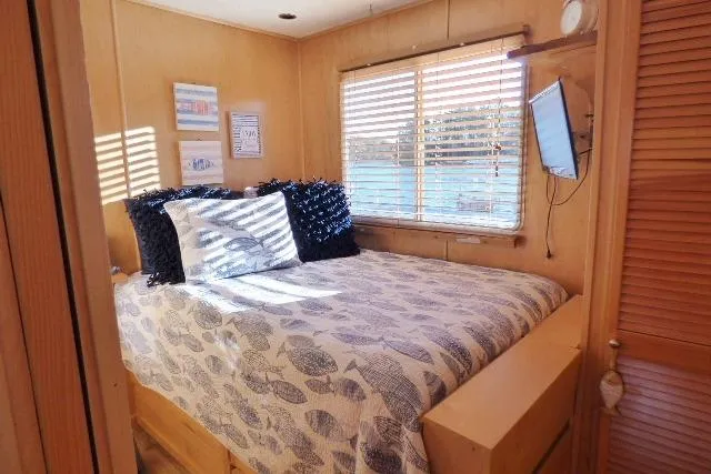 Slide: The Image of Cozy bedroom in 2001 Starlite 15x67 houseboat with nautical decor and natural light. - 6