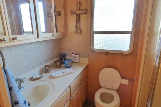 Slide: The Image of Bathroom interior of 2001 Starlite 15x67, featuring wooden cabinets and decorative crosses. - 7