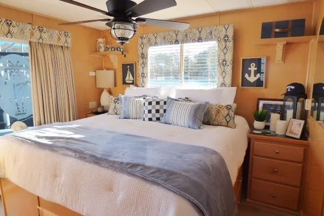 Slide: The Image of Cozy bedroom in a 2001 Starlite 15x67 houseboat with nautical decor and ceiling fan. - 8