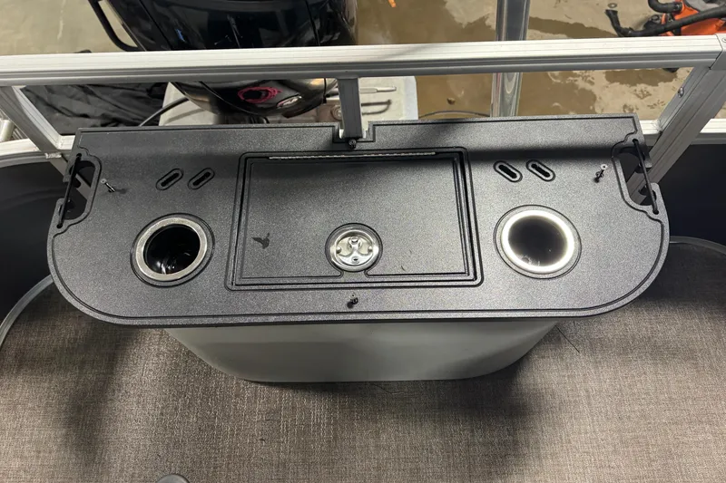 Slide: The Image of 2023 Ranger Reata 220F boat console with cup holders and storage compartment. - 17