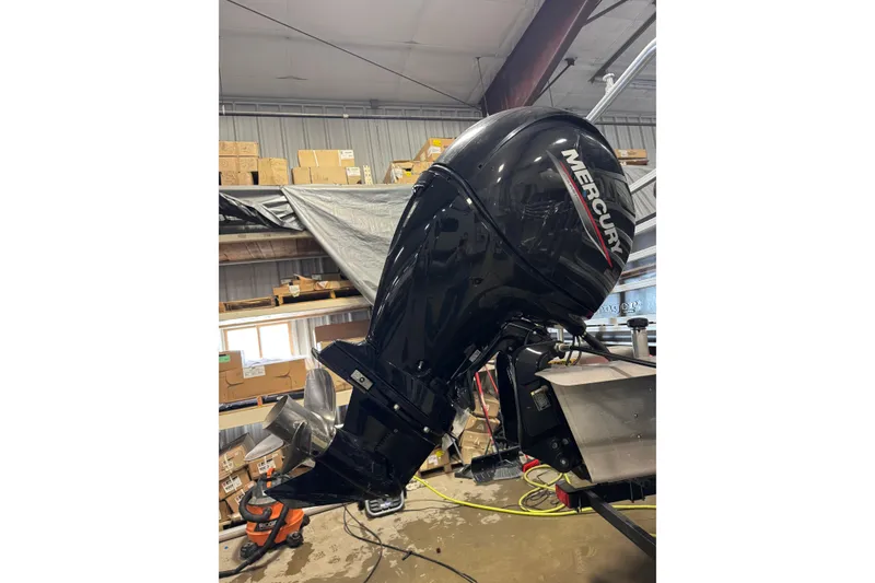 Slide: The Image of 2023 Ranger Reata 220F with Mercury outboard motor in a workshop setting. - 6