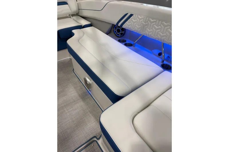 Slide: The Image of 2026 Regal LS6 Surf boat interior with white and blue seating, ambient lighting. - 22