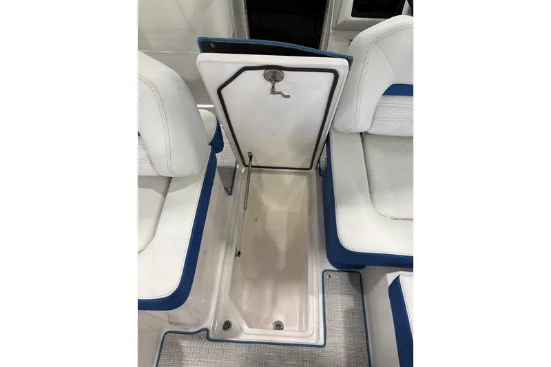 Slide: The Image of 2026 Regal LS6 Surf boat interior storage compartment with white and blue seating. - 24