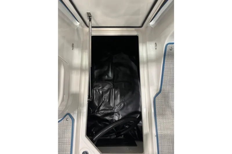 Slide: The Image of 2026 Regal LS6 Surf boat storage compartment with black interior and textured flooring. - 25
