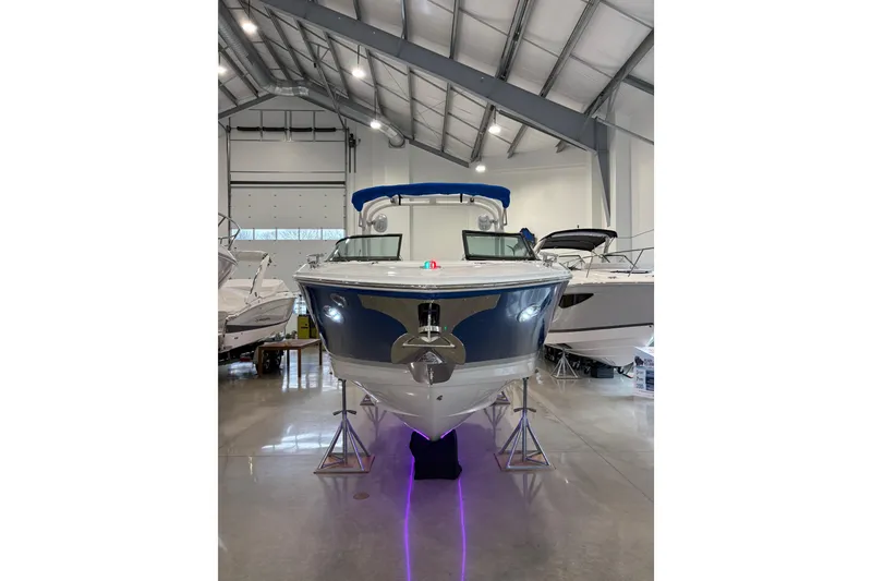 Slide: The Image of 2026 Regal LS6 Surf boat displayed in a showroom with sleek design and blue accents. - 4