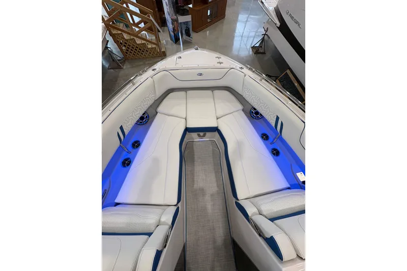 Slide: The Image of 2026 Regal LS6 Surf boat interior with white and blue seating, ambient lighting. - 8