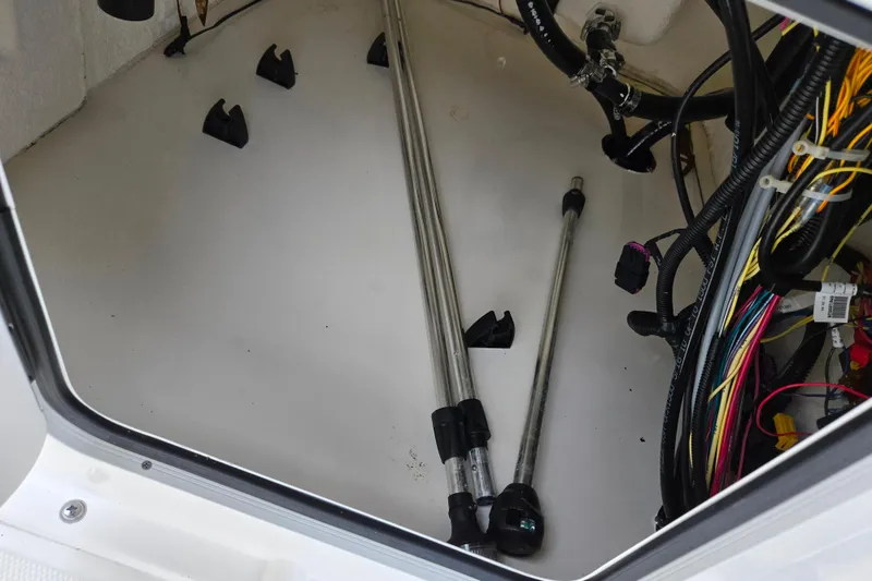 Slide: The Image of 2022 Bayliner Trophy T21Bay storage compartment with rods and wiring. - 14