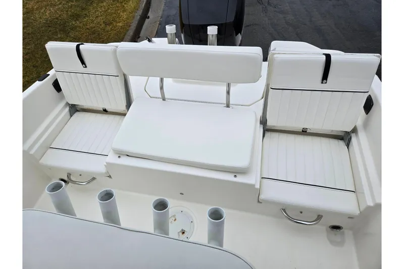 Slide: The Image of 2022 Bayliner Trophy T21Bay boat interior with white cushioned seating and rod holders. - 27