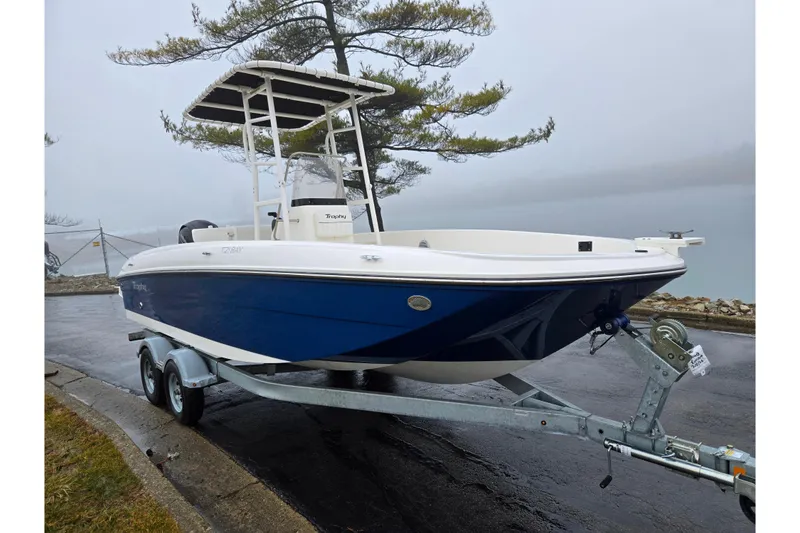 Slide: The Image of 2022 Bayliner Trophy T21Bay boat on trailer, parked near a misty lake. - 8