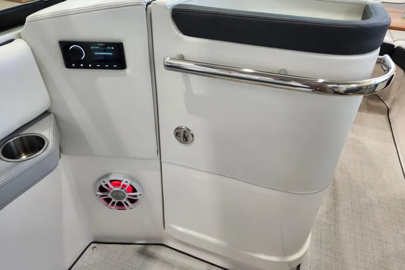 Slide: The Image of 2025 Regal LX6 boat interior with audio system, speaker, and cup holder. - 26