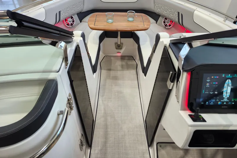 Slide: The Image of 2025 Regal LX6 boat interior with modern dashboard, seating, and wooden table. - 30