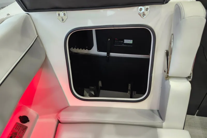 Slide: The Image of 2025 Regal LX6 boat interior storage compartment with red ambient lighting. - 41