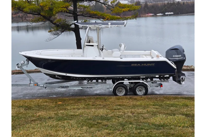 The Image of 2012 Sea Hunt Ultra 234 boat on trailer by a lake. - 0