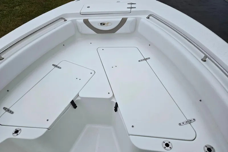 Slide: The Image of 2012 Sea Hunt Ultra 234 boat deck with storage compartments and seating area. - 16