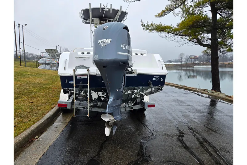 Slide: The Image of 2012 Sea Hunt Ultra 234 boat with Yamaha 250 V6 engine by a lake. - 2